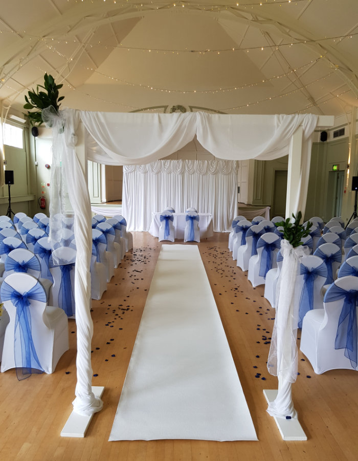 wedding ceremony decor with arch, backdrop and aisle runner