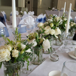 Table Decor with glass candle holders candles jars and flowers