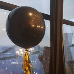 large black balloon with gold tassels