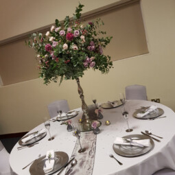 large floral wedding centerpiece on silver pedestal
