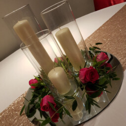 cylinder vase centrepiece with candles and flowers on a mirror plate