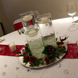 cylinder vase centrepiece with floating candles and flowers on silver plate