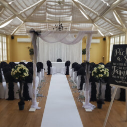 black and white ceremony room decor with starlit back drop, arch and signage