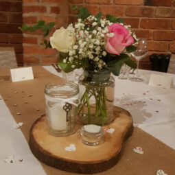 rustic wedding centrepiece with jars and log slice