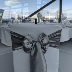 wedding breakfast room with silver taffeta chair sashes