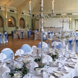 wedding breakfast tables with chrome candle holders and greenery